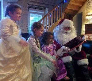 Père Noël à domicile avec livre et enfants