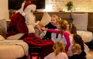 Père Noël assis avec enfants et livre