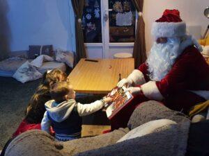 Père Noël à domicile avec livre et enfants